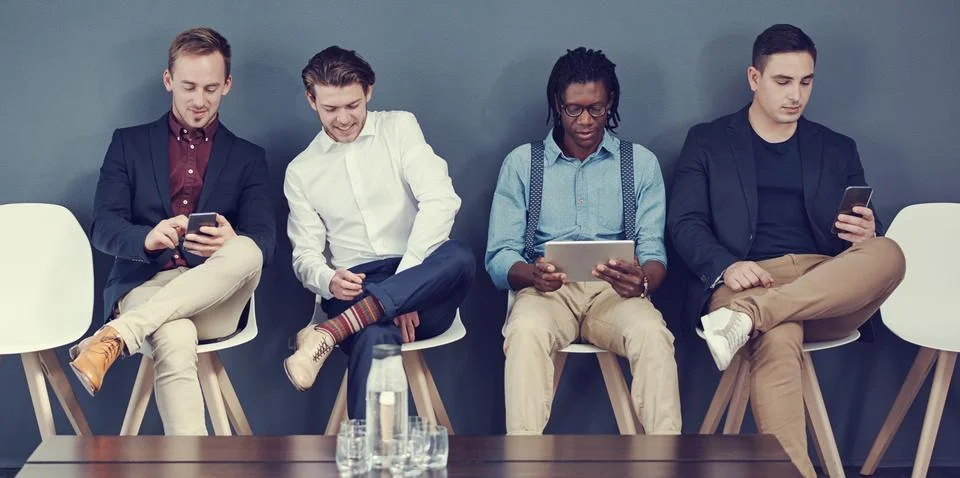 The men are ready for the interview. a group of businessmen using different Stock Photos