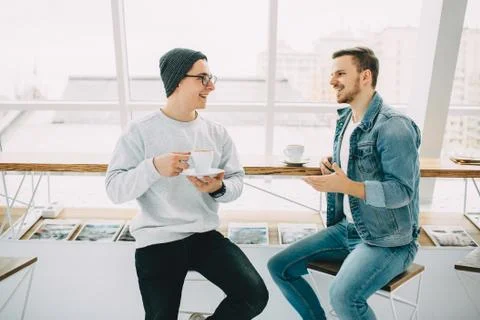 Men are sitting in front of the table near window Stock Photos