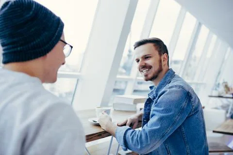 Men are sitting in front of the table near window Foto stock