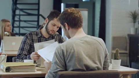 Men are sitting at table in modern offce and shaking hands, making agreement Vídeos de archivo 78722456