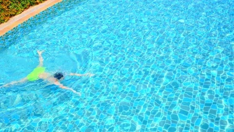 Men are swimming or diving in the pool. Young man exercising or relaxing in the  Stock Footage 180534598