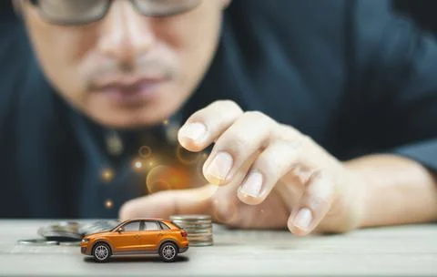 Men are using their hands to grab car models and coins to save money for thei Foto stock
