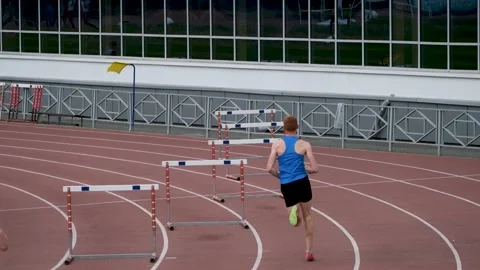 Men athletes running 400 meter hurdles race Stock Footage 200468616