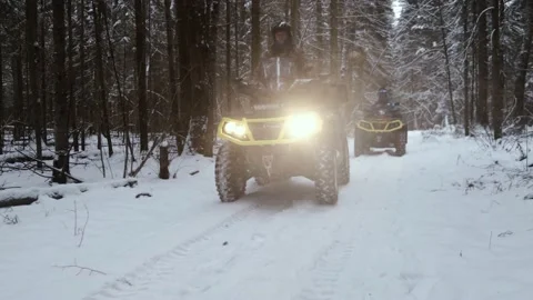 Men on ATVs ride through the winter forest Stock Footage 161178198