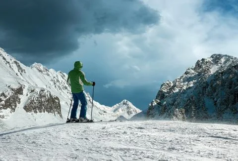 Men with backpack at ski goes to the top of mountain in sun day Stock Photos