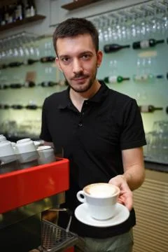 Men barista hold coffee cup. Serving a client. Stock Photos