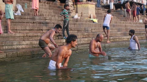 Men bathing on the ghats of Ganges river... | Stock Video | Pond5