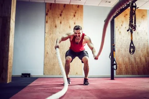 Men with battle rope in functional training fitness Stock Photos