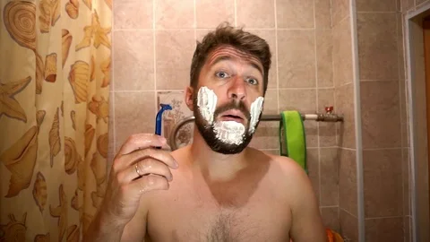 Men with beard uses a single blade safety razor to shave his beard Stockbeeldmateriaal 93819226