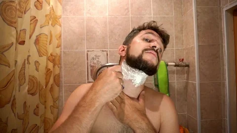 Men with beard uses a single blade safety razor to shave his beard Видео 93819412