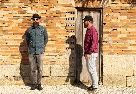 Men with beards in front of the wall Stock Photos