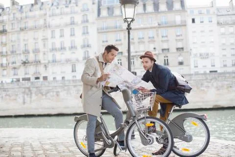 Men on bicycles reading map along Seine River, Paris, France Foto stock