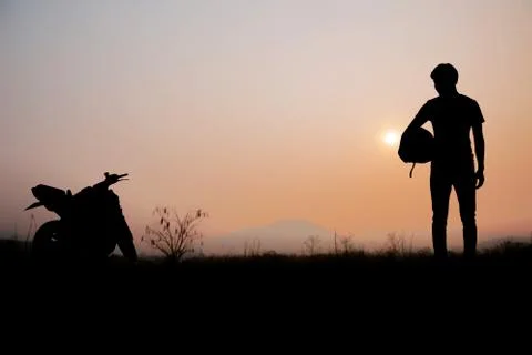 Men of biker with sunset. Stock Photos
