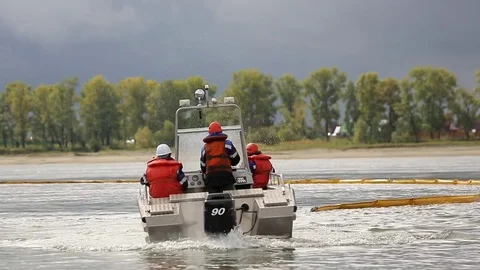 Men in a boat with orange vests put the net in the water Stock-Footage 76860738