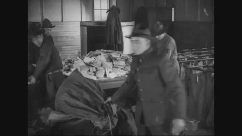 Men bring in and empty the mail bags at the Parcel Post Division - 1917-1918 Stock Footage 83702639
