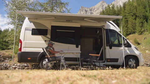 Men Browsing Internet Outside of His RV Motorhome on a Camping Stock Footage 141040778