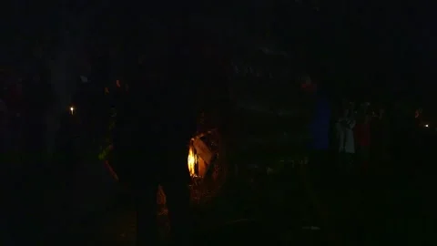 Men with burning torches light a large wheel of fire on a midsummer night Stock Footage 253395431