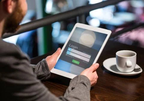 Men in a cafeteria with tablet in login screen Stock Photos