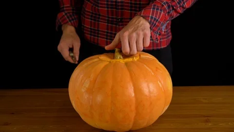 Men Carve Jack O' Lantern pumpkin for Halloween Celebration Stock Footage 116571650