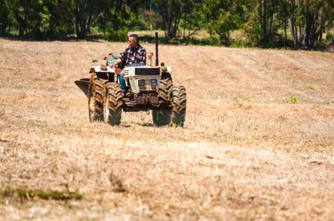 Men chat while working with the tractor Stock Photos