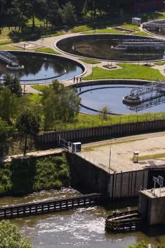 Men checking water storage tanks at sewage treatment plant Stock Photos