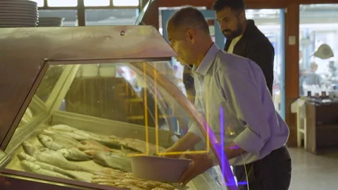 Men choosing fresh fish at a local seafood market Izmir Turkey 7 Mayıs 2023 Stock Footage 332079520