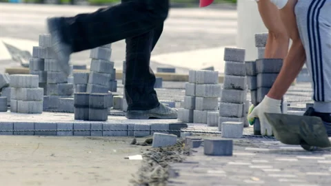 Men city workers bring and lay paving slabs on flat surface Stock Footage 243660008