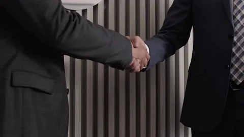 Men in classic jackets shake hands after making a deal Stock Footage 212388616