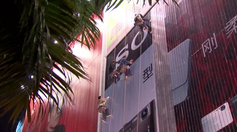 Men cleaning side of building in harnesses, China Video stock 54534837