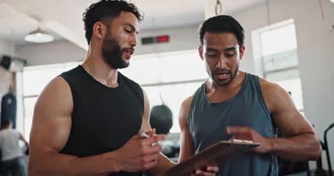 Men, coach and talking with clipboard at gym with planning workout with advice Stock Footage 290061054