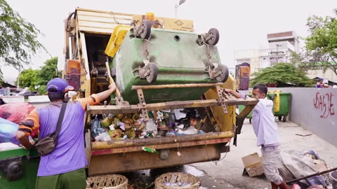 Men collaborates to loading trash from plastic recycle container to the trash tr Stock Footage 248090405