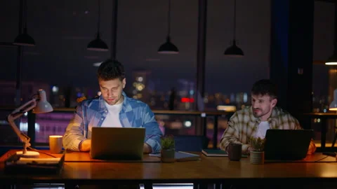 Men colleagues working together collaborating project at dark cabinet interior Stock Footage 339299241