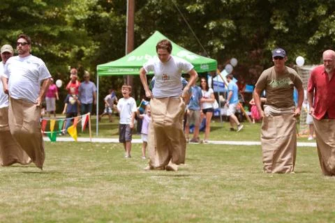 Men compete in sack race at spring festival Foto stock