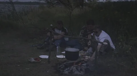 Men cook over a campfire Stock Footage 34646365