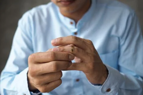 Men decided to remove the wedding ring and prepare to divorce documents. Stock Photos