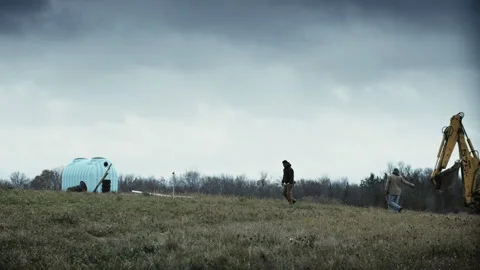 Men directing an earth mover in digging an archaeological discovery Stock Footage 202898230