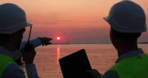 Men discuss port work using tablet and radio set by seaside 스톡 동영상 166054391