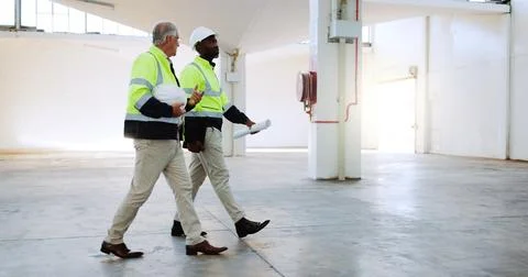Men, discussion and construction worker at warehouse, inspection or review for Stock Photos