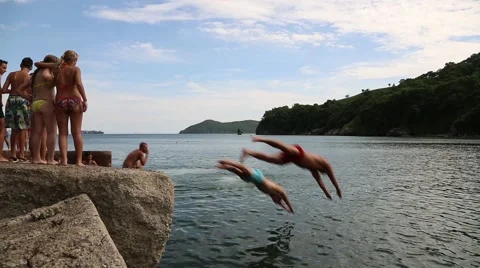 Men diving into the sea from the old dock. Russia Stock Footage 53312451
