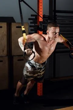Men doing push ups training arms with trx fitness straps in the gym Fotos de archivo