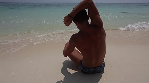 Men is doing yoga exercise on the beach Stock Footage 57357487