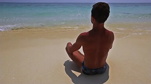 Men is doing yoga exercise on the beach Stock Footage 57358234