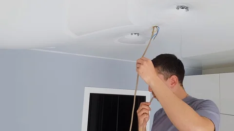 Men is drain water from a stretch ceiling filled with water through a tube. Stock Footage 128256811