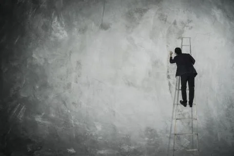 Men drawing on empty grey wall . Stock Photos