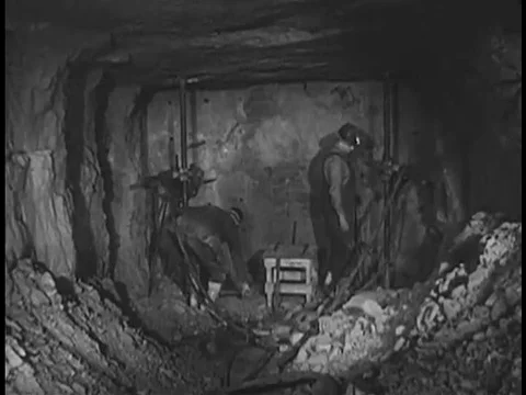Men drill and load dynamite into the drilled rock where they wire it together 動画素材 74999051