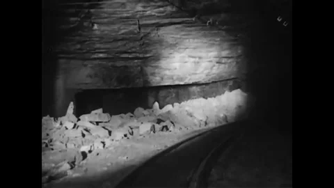 Men drill and load dynamite into the drilled rock where they wire it together 動画素材 79537177