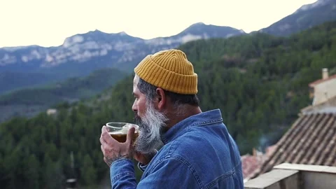 The men drink tea from a cup and relax on the terrace at home on sunny days. Stock Footage 167823582