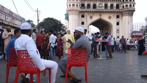 Men drinking chai in front of famous Charminar monument Stock Footage 98571034