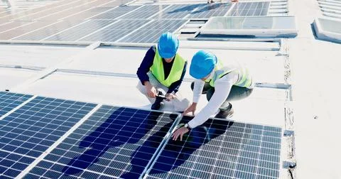 Men, engineer and team for solar panel with tablet on roof, discussion or Stock Photos
