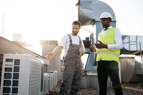 Men engineer standing and working with conditioner outdoor Stock Photos